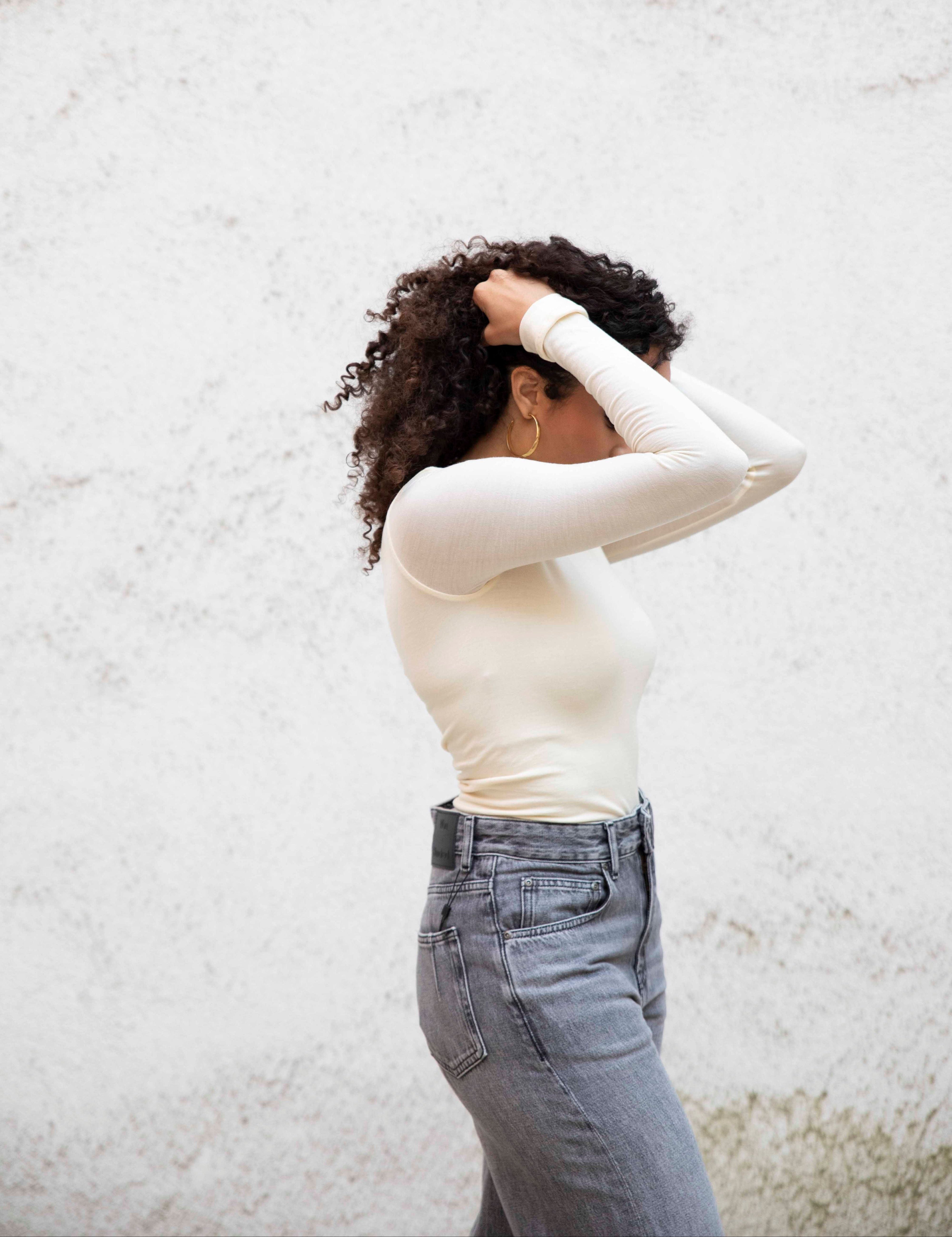 VALENTINA boatneck top with seamless bodice, tucked into jeans, three-quarter side view, bright cream