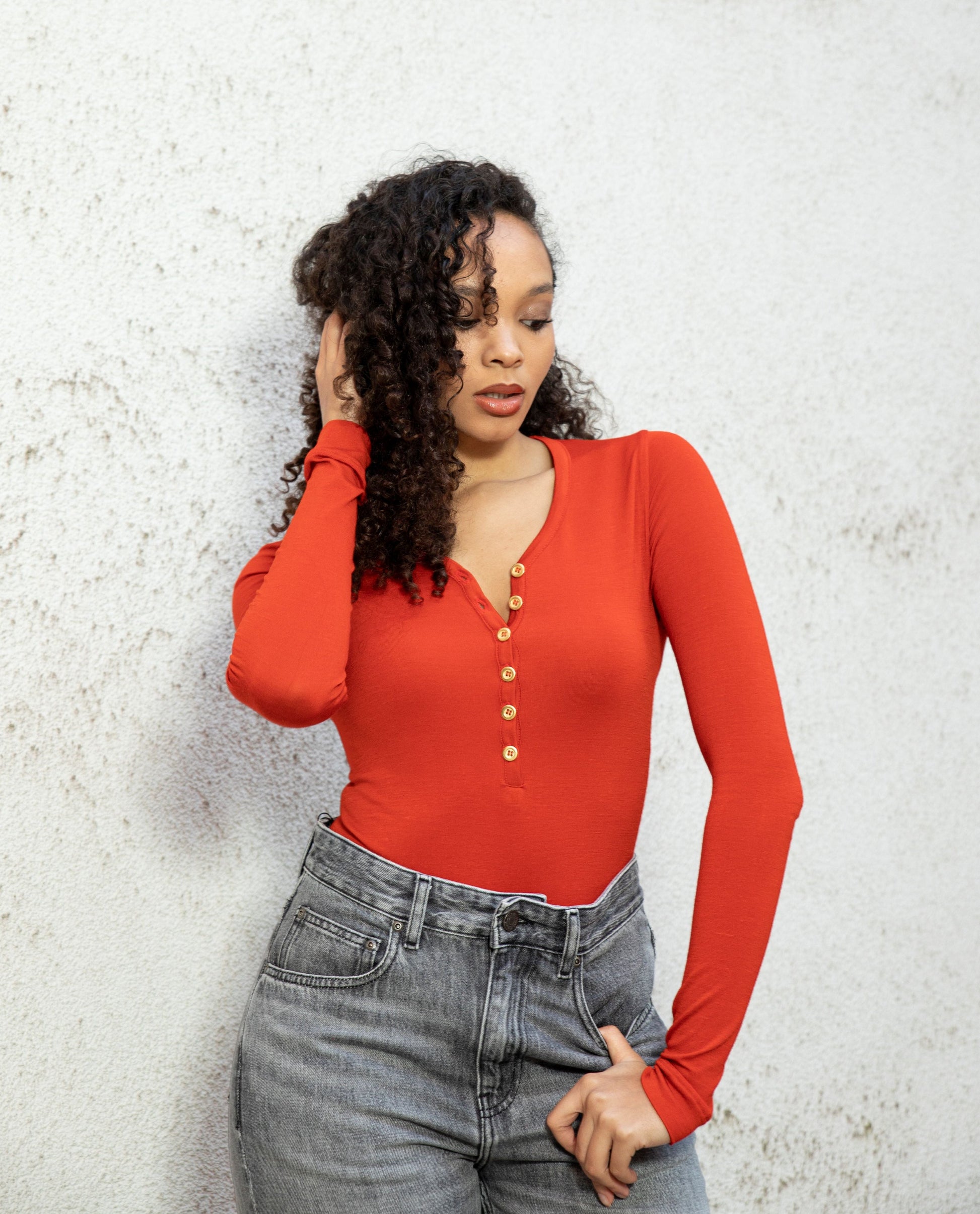 MARA long-sleeve V-neck bodysuit crafted in Italy from superfine merino, seamless bodice with button placket, burnt red