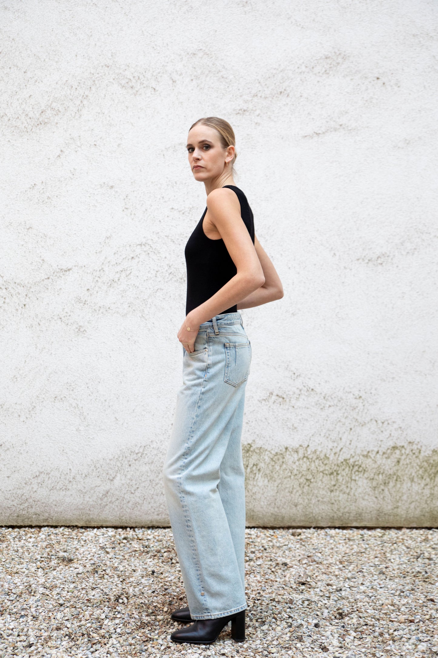 CLEO seamless tank bodysuit styled with jeans, side view, black