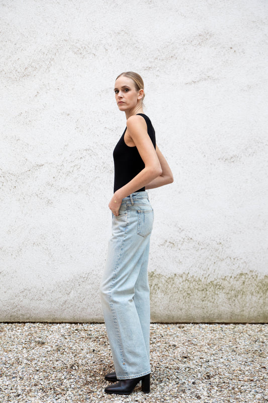 CLEO seamless tank bodysuit styled with jeans, side view, black