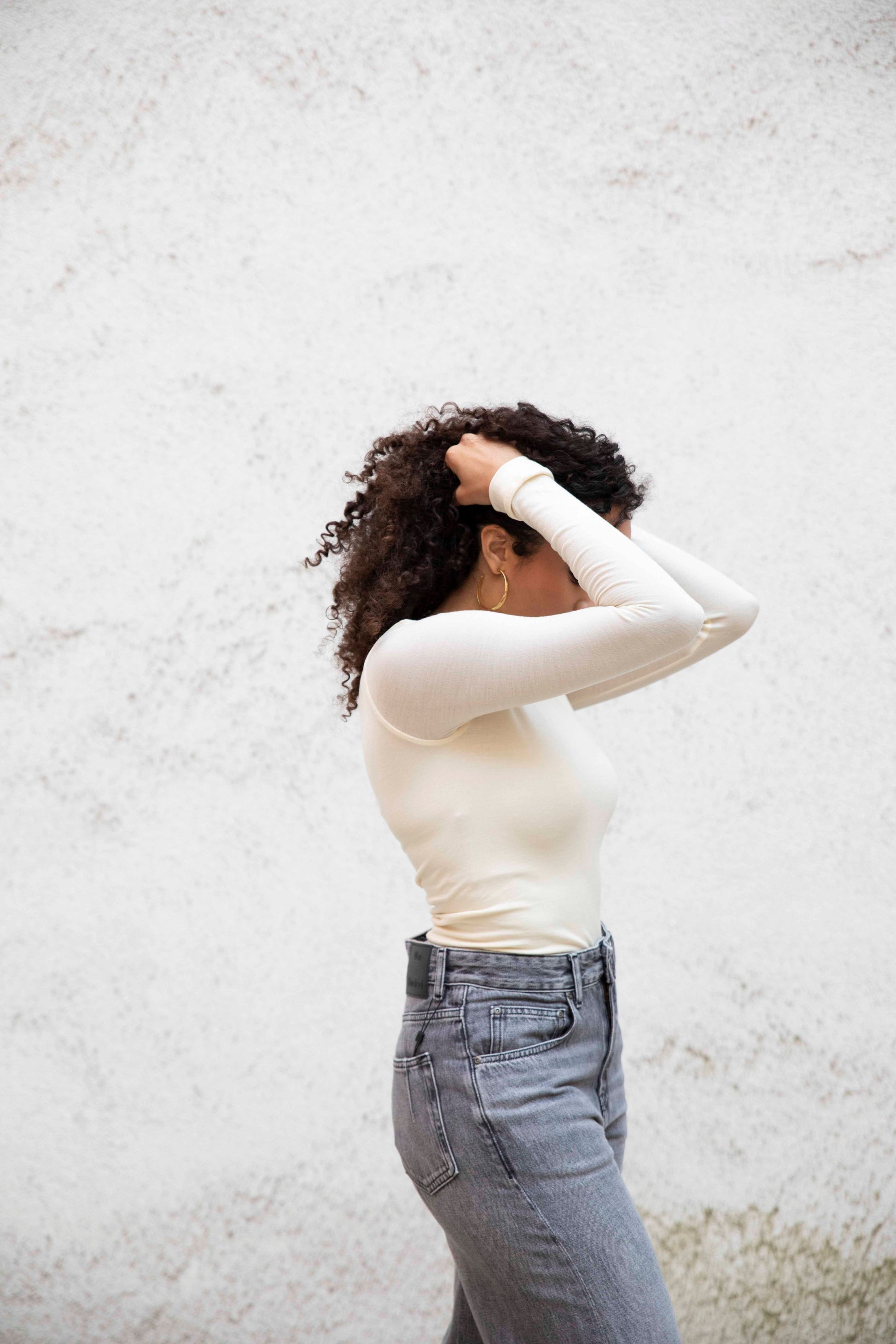 VALENTINA boatneck top with seamless bodice, tucked into jeans, three-quarter side view, bright cream