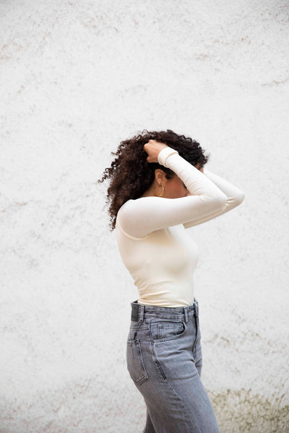 VALENTINA boatneck top with seamless bodice, tucked into jeans, three-quarter side view, bright cream