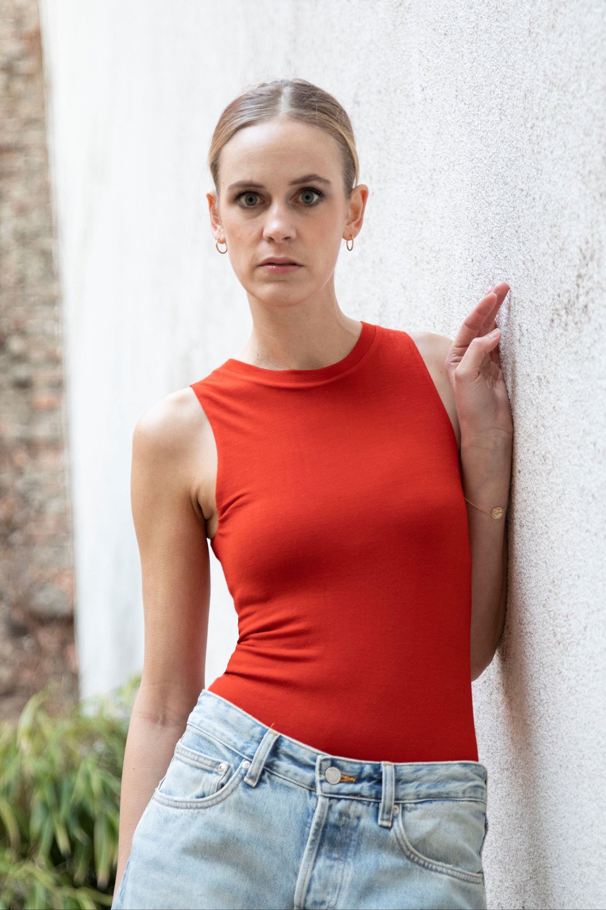 CLEO seamless tank bodysuit styled with jeans, three-quarter view, burnt red